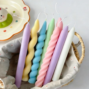 Macro shot of colorful spiral and wavy long pillar candles in a decorative woven basket
