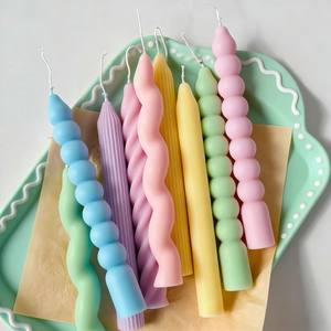 Detail view of colorful spiral and bubble pillar candles on a tray for home decor