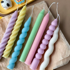 Close-up of assorted ribbed and spiral soy candles in macaron pastel colors on a tray