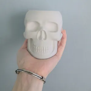 Skull shape silicone mold for resin or concrete flower pot being held by hand