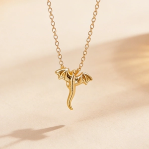 Gros plan sur un collier avec pendentif dragon volant doré de style punk rétro