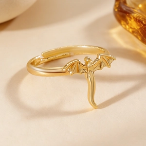 Gros plan détaillé d'une bague ouverte dorée au style punk dragon avec un fini poli