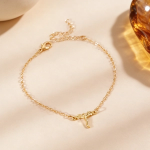 Gros plan détaillé d'une breloque dragon doré sur un bracelet à chaîne délicate