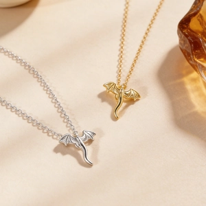 Vue macro détaillée de pendentifs dragon volant en or et argent sur des chaînes fines