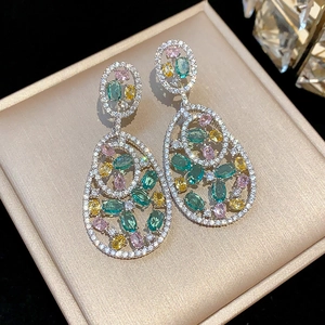 Close-up of vintage multi-color zircon earrings on a satin jewelry box
