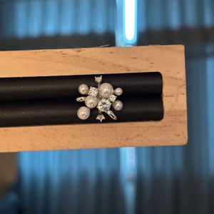 Vista macro dettagliata dell'elegante ear cuff a forma di fiore con perle e zirconi luccicanti