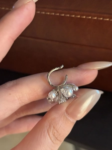 Vista dettagliata di un elegante ear cuff in argento con perle bianche e zirconi