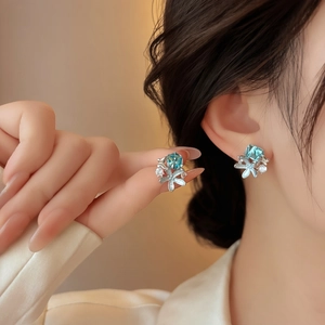 Close-up of elegant starfish stud earrings with blue glass stones and sparkling accents for women