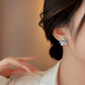Detail view of light blue starfish earring worn on ear, showcasing crystal accents.