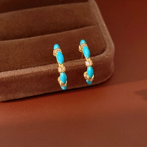 Vintage gold C-shaped earrings with vibrant blue stones and sparkling zircon details.