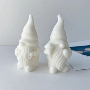 Dettaglio di candele gnomo bianche con scritta LOVE e motivi floreali decorati