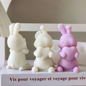 Detailed view of cute rabbit-shaped candles holding hearts on a decorative book