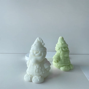 Detail of cute Santa Claus scented candles in white and green with matte finish