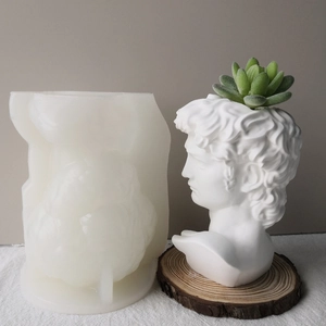 Detail view of David sculpture silicone mold next to finished plaster succulent planter pot