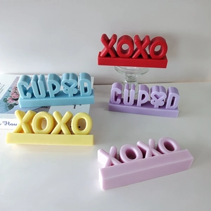 Detailed view of colorful XOXO and CUPID scented candle silicone molds for DIY crafts