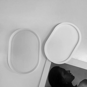 Top view of two minimalist white oval resin trays on an artistic lifestyle background