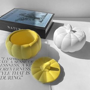 Detail of yellow and white pumpkin storage jars with realistic lids and matte finish