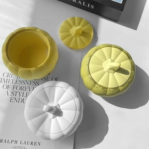 Three pumpkin-shaped storage jars in white yellow and green matte finish for Halloween