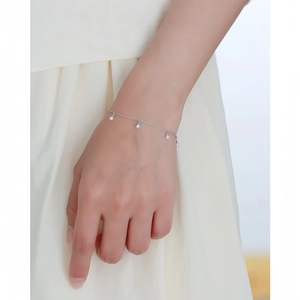 Vue détaillée d'un bracelet en argent s925 avec perles délicates porté au poignet.