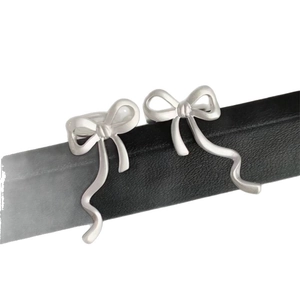 Minimalistische silberne Schleifen-Ohrklemmen ohne Piercing, elegantes Band-Design-Schmuck.