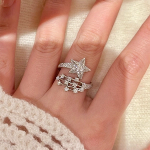 Detailaufnahme eines eleganten silbernen offenen Rings mit Zirkonstern am Finger