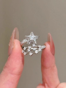 Detailaufnahme eines eleganten silbernen offenen Rings mit funkelndem Zirkonia-Sternmotiv
