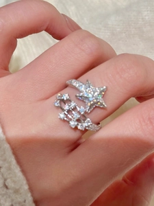 Nahaufnahme eines eleganten silbernen offenen Rings mit funkelnden Zirkonia-Sternen an der Hand