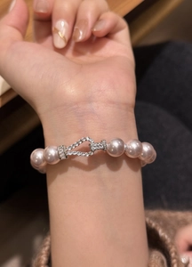 Close-up of an elegant pink pearl bracelet with a sparkling zircon-encrusted buckle