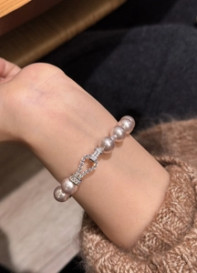 Detailed macro shot of an elegant pink pearl bracelet featuring a zircon clasp detail