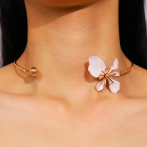 Close-up detail view of a vintage gold floral choker necklace with white enamel petals