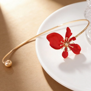 Detail view of an elegant vintage gold choker with a vibrant red enamel flower pendant.