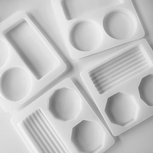 Detail of white silicone resin molds in various geometric shapes for DIY coaster crafts