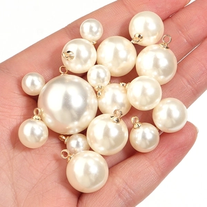 Macro detail of cream pearl pendants with gold metal loops for DIY jewelry making