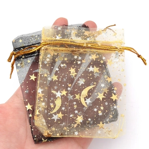 Detail der Organza-Geschenktüte mit goldenen Stern- und Mondmustern und Kordelzug