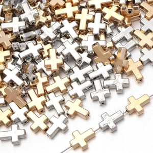 Detalle macro de cuentas de cruz en oro y plata con orificios de roscado horizontales