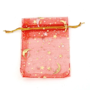 Detailansicht eines roten Organza-Geschenkbeutels mit Goldfolien-Sternen und Monden