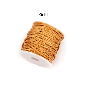 Primer plano de cordón de PU trenzado dorado enrollado en un carrete de plástico blanco