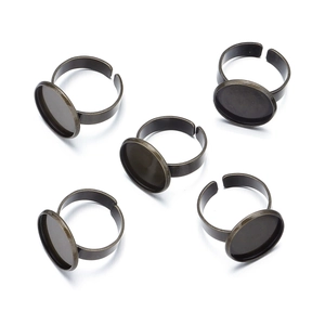 Detail of five bronze adjustable ring blanks with circular bezel settings for DIY jewelry