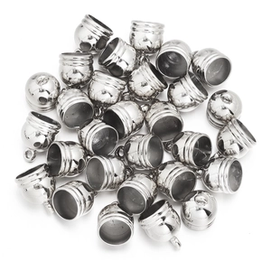 Close-up of shiny silver bell-shaped tassel caps and jewelry cord ends for DIY crafting