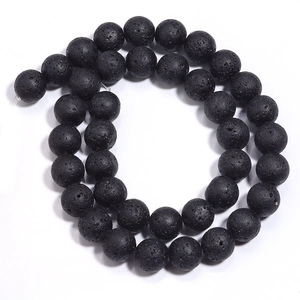 Macro shot of natural black volcanic lava stone beads with porous texture for DIY jewelry