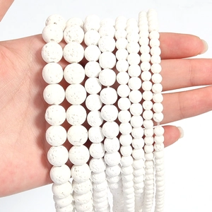 Close-up of white natural lava stone beads in various sizes showing porous texture