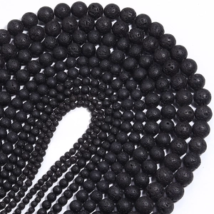 Macro shot of natural black lava stone beads showing porous texture in various sizes