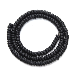 Macro detail of matte black wooden abacus beads arranged in a spiral coil over white background