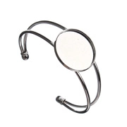Macro shot of silver metal open bangle with 25mm round blank tray for DIY jewelry making