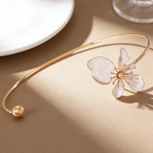 Macro detail of a vintage floral choker with elegant white enamel petals and gold finish