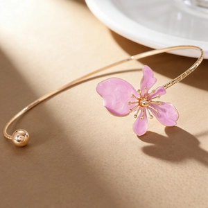 Close-up view of elegant vintage gold choker necklace with pink enameled flower charm