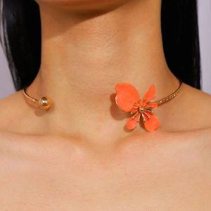 Close-up detail shot of vintage orange enamel flower petal choker worn on model neck
