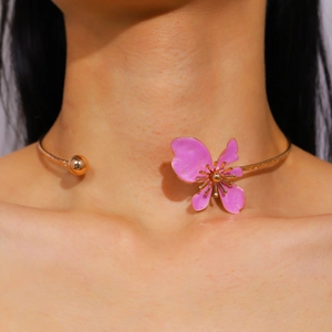 Close-up detail of a vintage pink enamel flower choker necklace worn by a female model