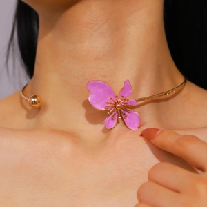 Detailed view of a vintage pink enamel flower choker necklace on female model neck