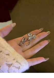 Close-up of sparkling heart flower zircon ear clips held in hand to show fine details